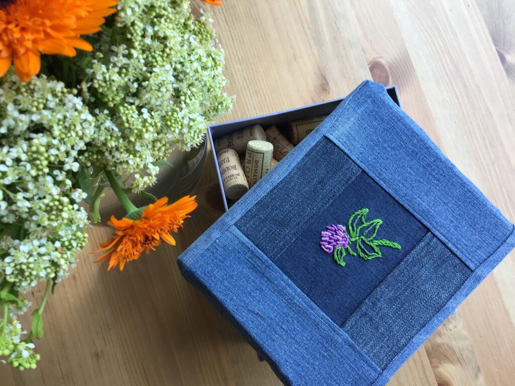 Recycled jeans used as base for a red clover embroidery