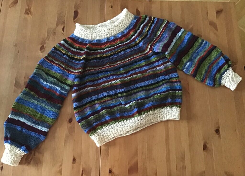 Sweater strikket af garnrester i forskellige farver og kvaliteter